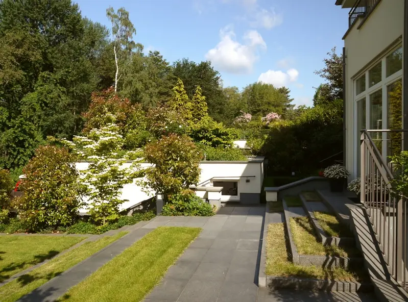 Das begrünte Garagendach wird Bestandteil der Sichtschutz-Pflanzung zum Nachbar und zur Straße. Die Straße ist von Haus und Garten aus optisch nicht mehr wahrnehmbar. Die Waldkulisse erweitert den Gartenraum.
